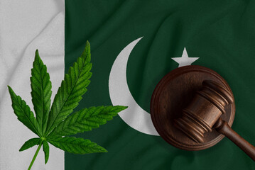 Cannabis leaf and judge gavel on the Pakistan flag background. Concept of legalization of marijuana