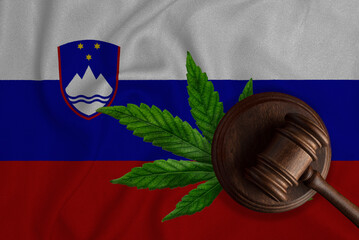 Gavel and cannabis leaf on the Slovenia flag background. The concept of legalization of marijuana...