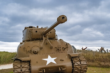 An American World War 2 M4 Sherman tank is facing the sunset on Utah beach, Normandy, France.