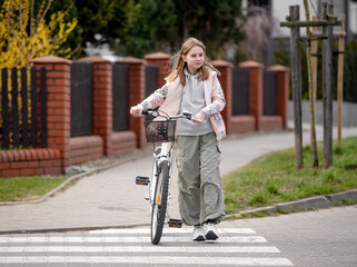 Girl Crosses Road On Pedestrian Crossing With Bicycle In Spring - 755229045