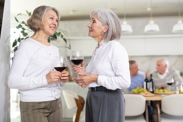 Elderly women sharing news and gossip during holiday dinner at home
