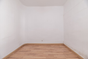 An empty room with white painted walls and wooden floors