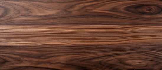 Fototapeta premium This close up view showcases the natural wood pattern and texture of dark brown walnut wood. The intricate details of the wood grain are visible, perfect for furniture making or parquet flooring.