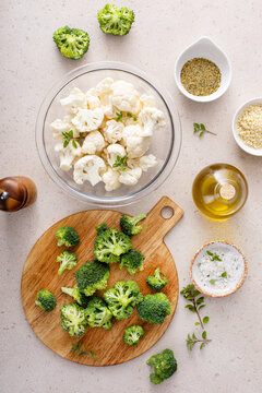 Cooking with broccoli and cauliflower, getting ready to roast vegetables with spices and olive oil