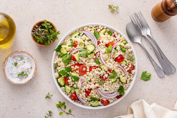 Pearl couscous salad with fresh vegetables and herbs, healthy side dish idea