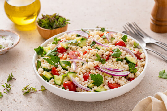 Pearl couscous salad with fresh vegetables and herbs, healthy side dish idea
