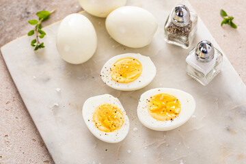 Boiled eggs peeled and cut in half with salt and pepper - 755240270