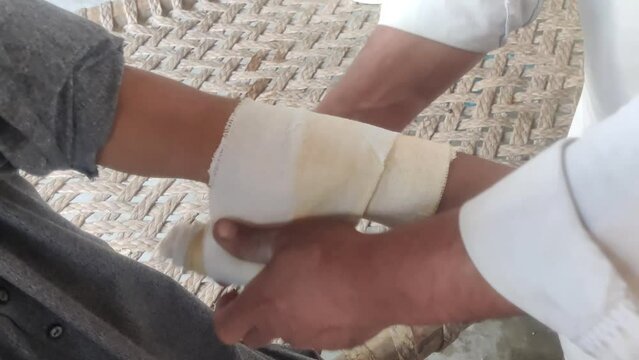 Traditional Pakistani Hakeem Treating Boy's Broken Arm with Herbal Remedy