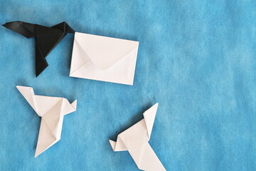 Paper origami of black raven stealing a white envelope letter from white dove. Data theft and lost...