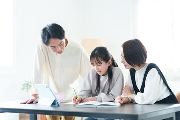 勉強をする女の子に教える両親