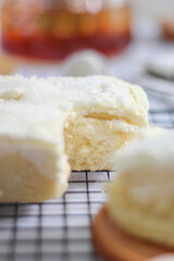 Close up of Milk Bun Thailand is a soft bread with a topping of powdered sugar, milk and vla filling,soft focus texture, served on black tray. white background. makanan viral indonesia