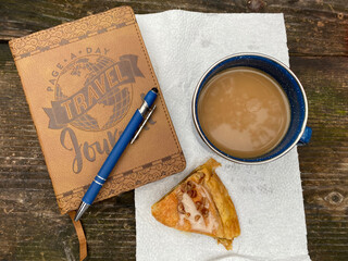 A journal, pen, cup of coffee and a piece of Danish start a day of travel.