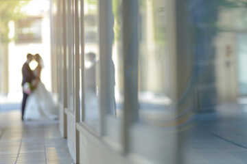 Blurred photo of a newly wed couple embracing in a sunlit corridor - obrazy, fototapety, plakaty