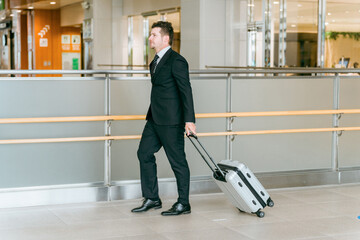 スーツケースを持って歩く欧米人のビジネスマン
