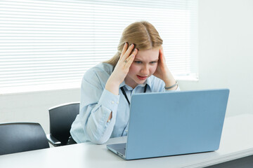 パソコンの前で頭を抱える女性　Business	