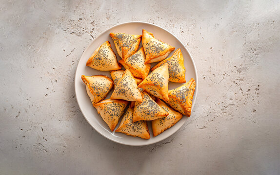 Top View Triangular Hamantaschen With Poppy Seed Filling On White Plate On Concrete Background. Traditional Jewish Pastry, Bakery Ai Generated. Purim Holiday. Horizontal.