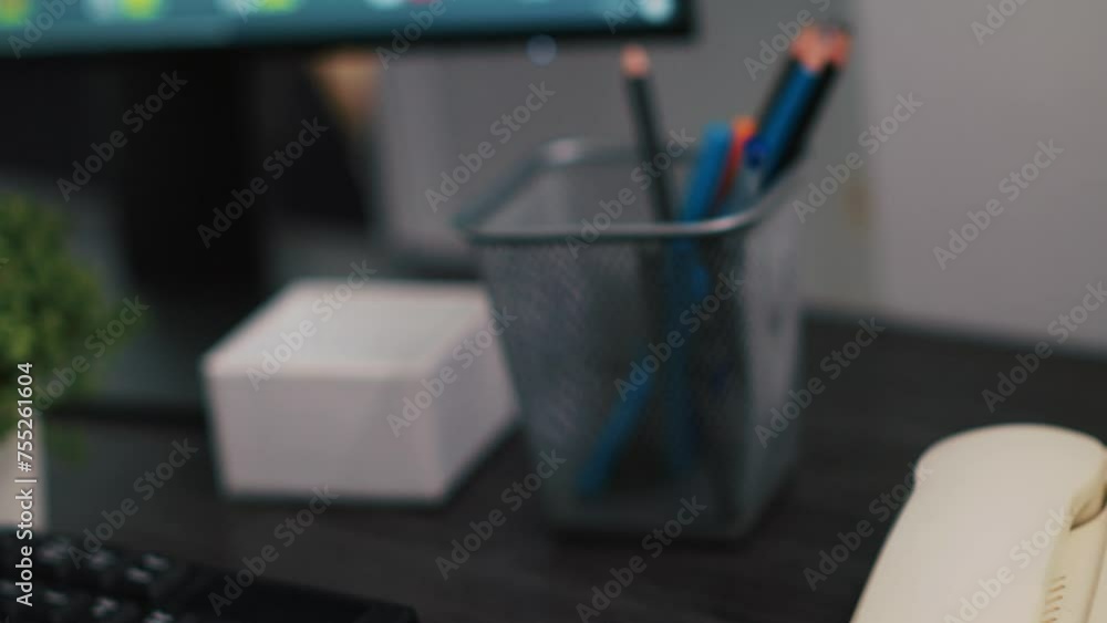 Poster close up shot of telephone on office desk and computer monitor showing stock exchange values going u