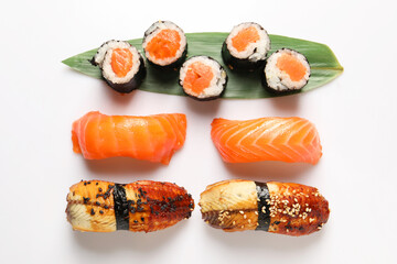 Different tasty sushi rolls on white background, flat lay