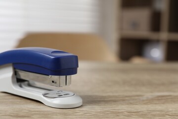 Bright stapler on wooden table indoors, closeup. Space for text