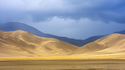 Fototapeta na wymiar Dramatic desert landscape under a stormy sky with sunlight highlighting golden sand dunes against dark mountain silhouettes