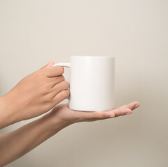 hand is holding a mug or glass on a white isolated background
