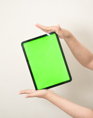 hand is holding a tab with green screen on a white isolated background