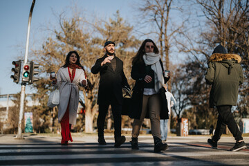 A diverse group of professionals is walking across the zebra crossing on a sunny winter day,...