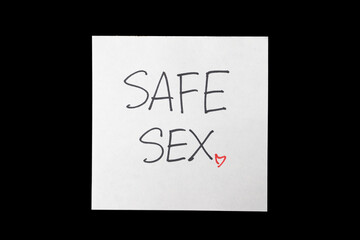 Text safe sex on paper note background. Sex protection, safe sex concept. Prevent infection. World contraception day. Protect yourself. AIDS awareness concept.