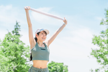 公園で運動・トレーニング・ウォーキング・ストレッチする女性(タオル・発汗・デトックス)
