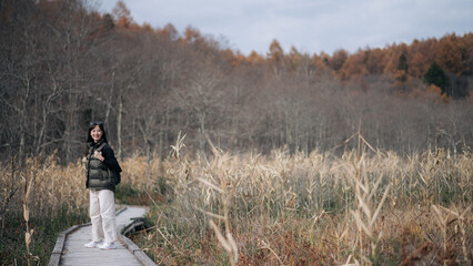 Nature's embrace, Asian traveler, a young Asian woman, revels in a solo hike along a scenic...