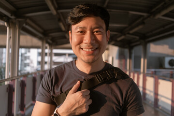 Close up of happy Asian man on the sky-train platform in Bangkok.