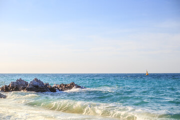 Ocean waves, clear seas and skies, buoys in the sea.