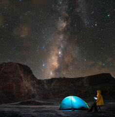Milkyway galaxy Night mountain landscape with an illuminated tent