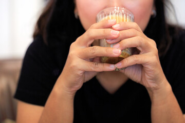 Portrait of Young Asian woman holding a hot cup of coffee, a happy and relaxing time in the cafe