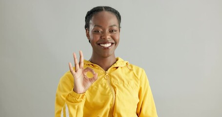 Woman, face and okay sign by studio for approval, agreement and satisfaction on gray background. Black female person, portrait and feedback for support, excellence and opinion or thank you for emoji