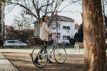 Obraz premium An elegant young woman looking back while riding a classic bike with a basket in an urban park setting.