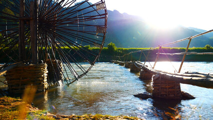 Wood water wheel Baler Machine in Agriculture Farm impeller lifted pumping water in river. Wooden Water Baler Machine green garden Farm blades by windy natural. Sustainable Resources Environment © aFotostock