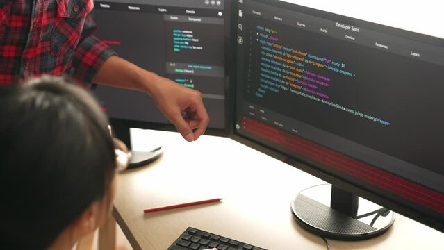 Slow motion back end or software developer manager supervising his team on new application program development on debugging and solving complex code algorithms on monitor. Burgeoning