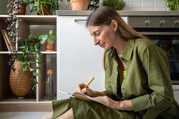 Focused woman reflects on thoughts, writing them down in notebook after therapy session. Engaged...