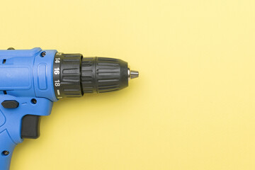 A blue screwdriver on a light yellow background.