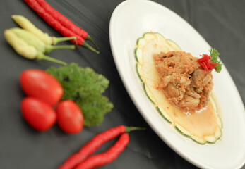 Cakalang Rica - Special Food from Manado Indonesia, made from Skipjack Fish Cooked in Spicy Aromatic Sambal. Served on white plate. Side view.
