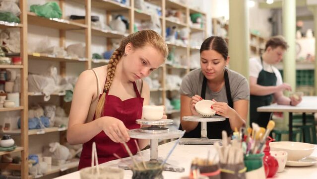 Girl teenager learns how to create pottery in the workshop. High quality 4k footage