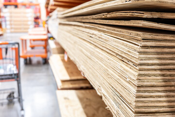 Selective focus on edge of stacked plywood in a retail store.