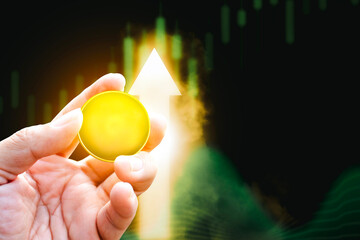 Bitcoin or cryptocurrency prices rise up positive, golden coin holding in a hand with up arrow...