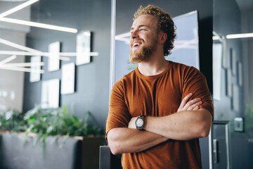 Caucasian man smiling as he stands outside a meeting room in a business office