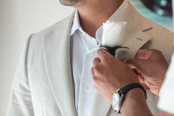 A boutonnière s a floral decoration, typically a single flower or bud, worn on the lapel of a...