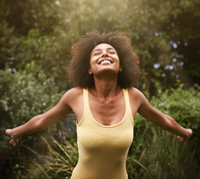 Happy, open arms and black woman in nature for freedom, adventure and relax in park. Smile, excited and person with happiness, positive attitude and fun outdoors for holiday, vacation and weekend