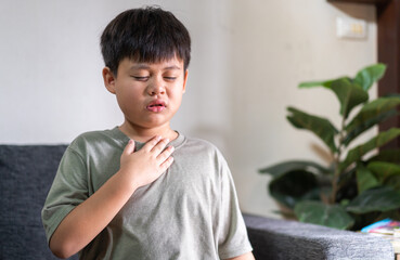 Sick asian boy touching neck unwell coughing with sore throat pain,lung cancer,bronchitis,Bronchial...