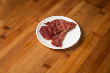 Beef Bacon slice served in plate isolated on wooden table top view of indian food