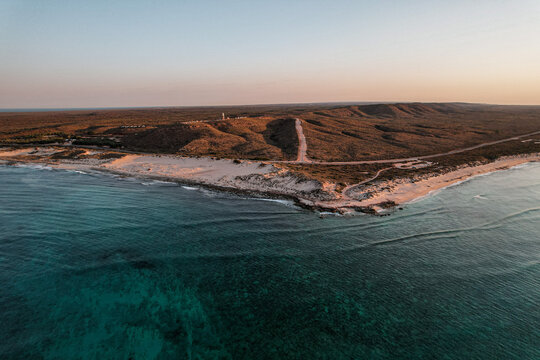 Aerial picture of a sunset over the lighthouse in Exmouth, Western Australia. Beach and ocean view from the sky. Transparent water. Ningaloo reef, Australia.